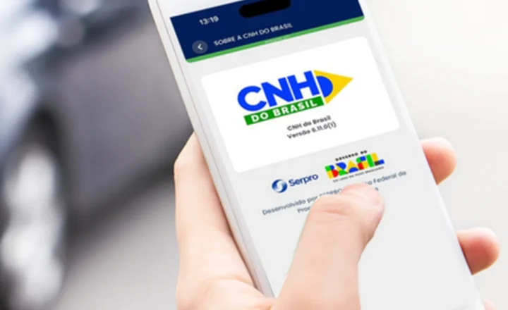 Detalhe de uma mão segurando um celular cuja tela exibe o app CNH do Brasil em funcionamento