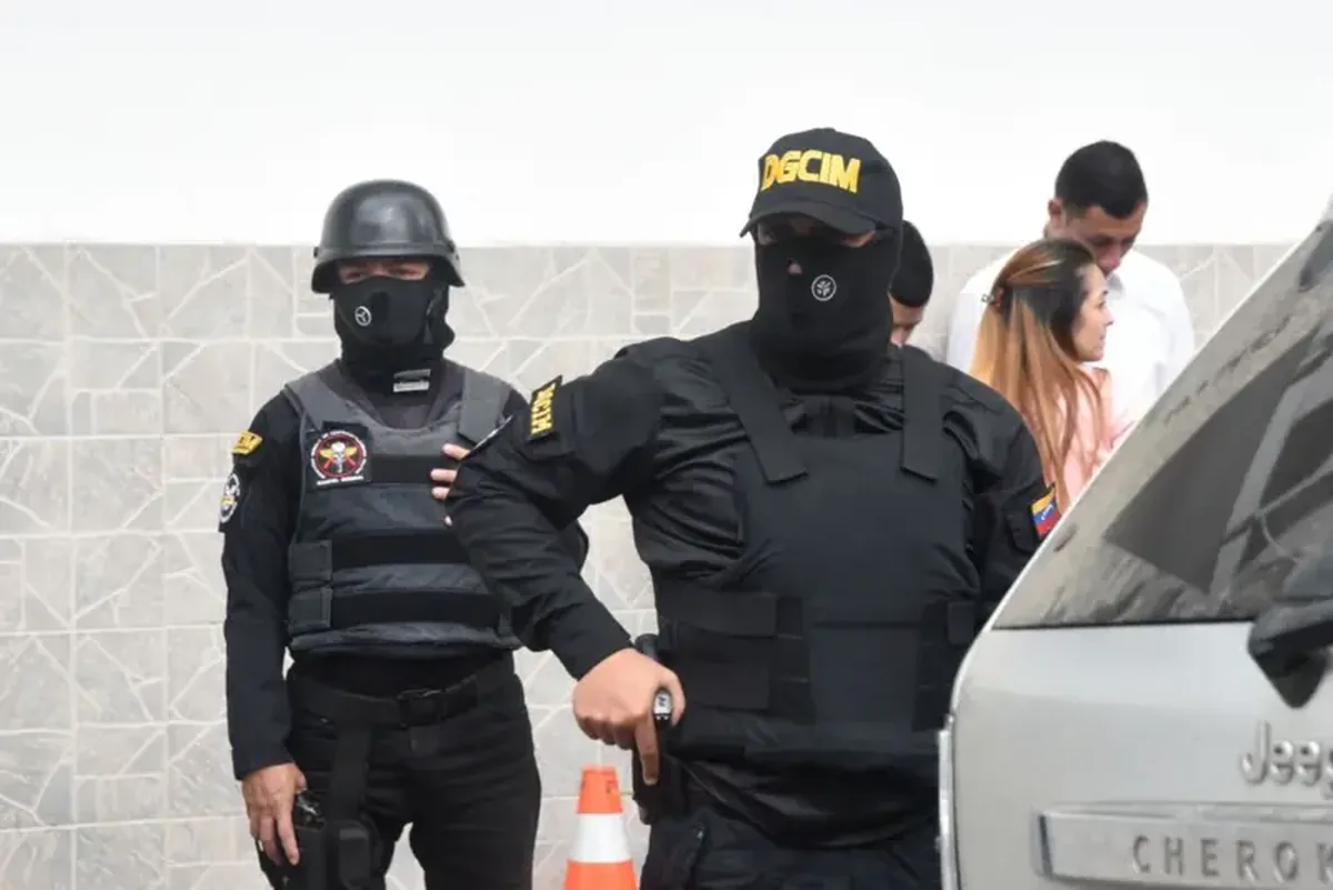 Dois agentes da Direção Geral de Contrainteligência Militar da Venezuela, com o rosto coberto e vestidos de preto