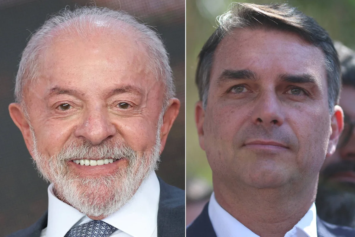Dois homens aparecem em retratos lado a lado. O da esquerda é um homem mais velho, com cabelo grisalho e barba branca, sorrindo, vestido com terno escuro, camisa branca e gravata azul. O da direita é um homem mais jovem, com cabelo escuro penteado para o lado, expressão neutra, vestindo terno escuro