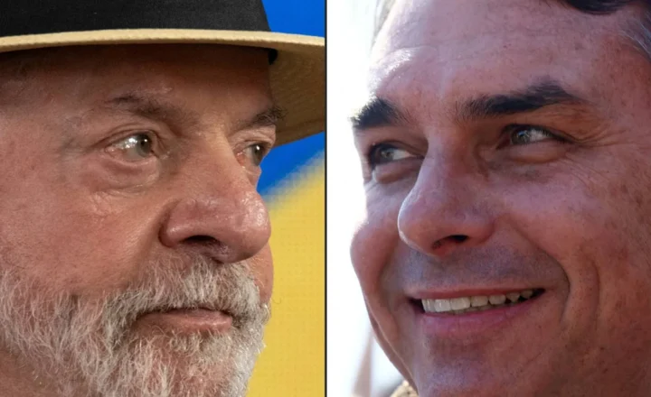 Close-up de dois homens, um à esquerda com chapéu de palha e barba grisalha, olhando para a direita, e outro à direita sorrindo, olhando para cima e para a esquerda