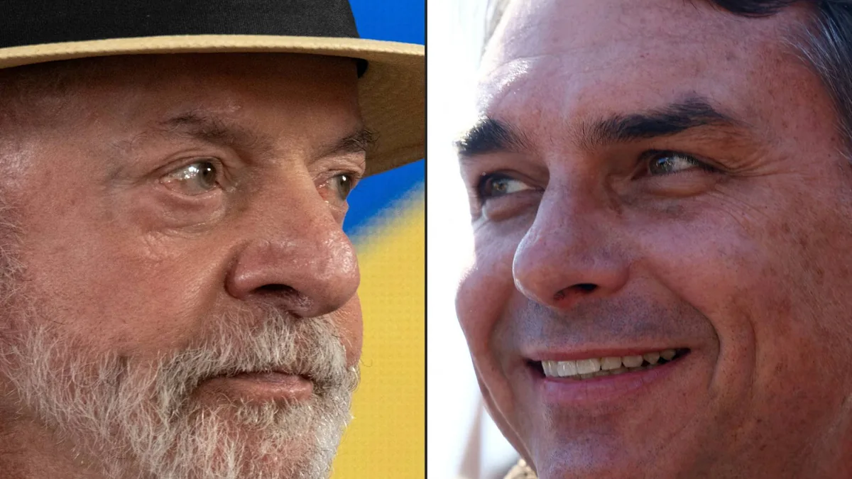 Close-up de dois homens, um à esquerda com chapéu de palha e barba grisalha, olhando para a direita, e outro à direita sorrindo, olhando para cima e para a esquerda